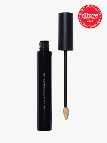 Make Beauty Skin Mimetic Concealer in branded black tube next to doe foot applicator cap on light gray background with red Allure Best of Beauty seal in the top right corner